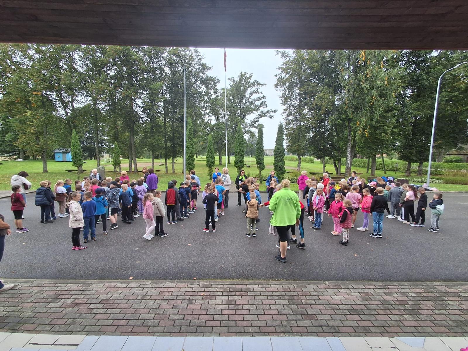Skolēni sapulcējušies laukumā un sporto