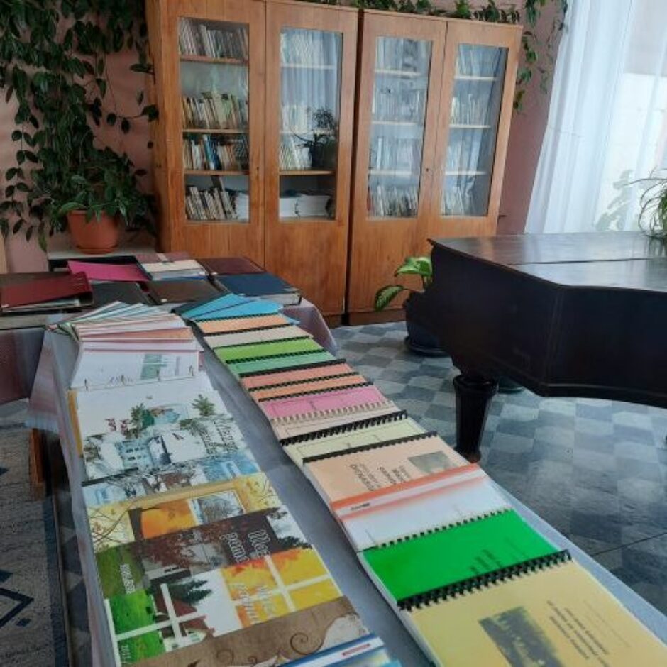 Grāmatas izliktas uz galda skolas bibliotēkā pie klavierēm