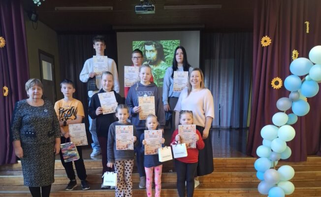 Skolēni stāv uz skatuves pakāpieniem